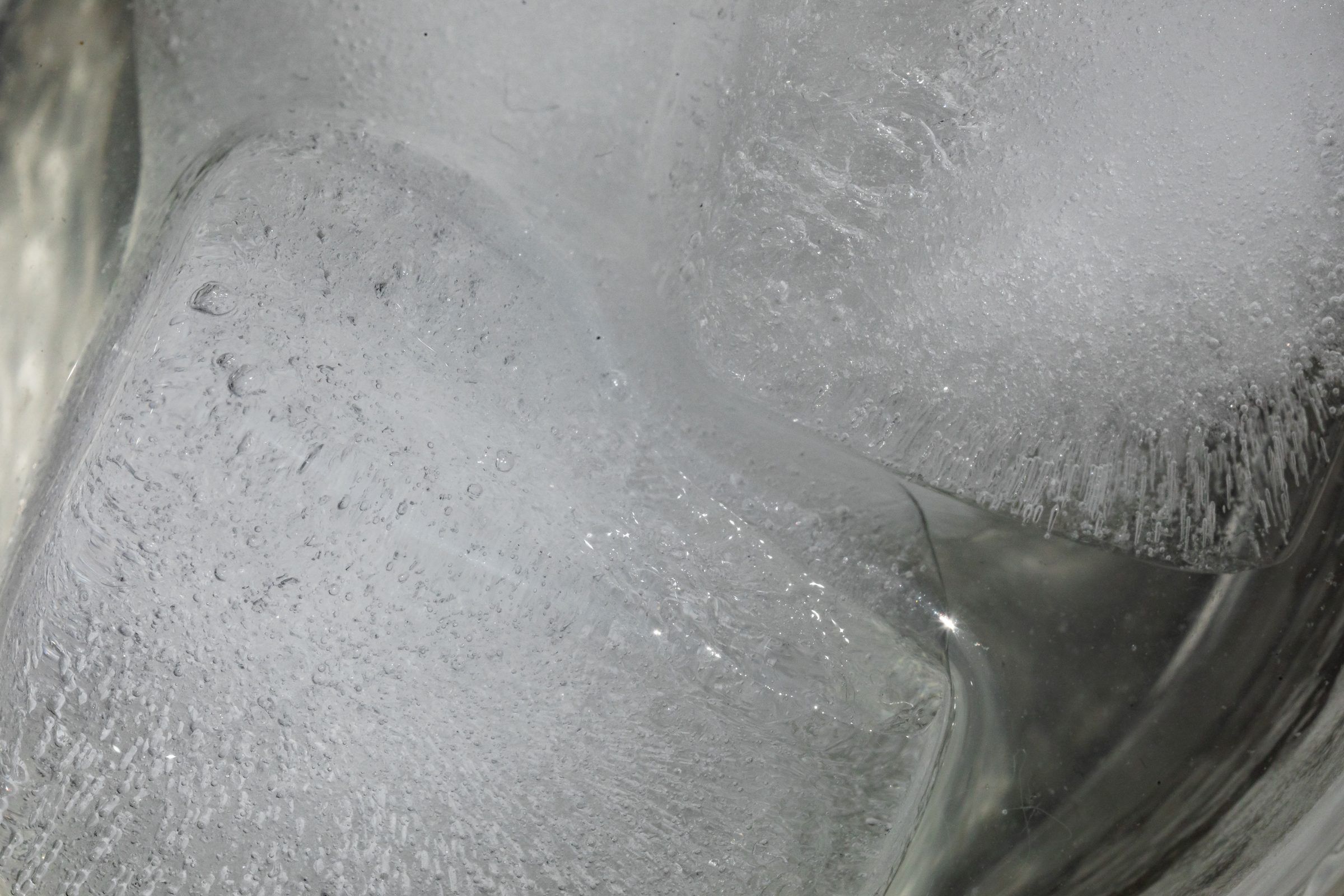 Close view of clouded ice cubes floating in clear water
